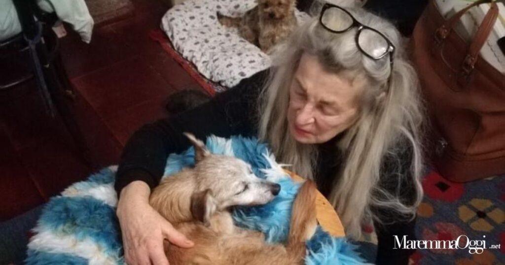 Helga con uno dei suoi cani sul divano di quella che era la sua casa, prima del rogo