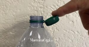 La bottiglia di plastica con il tappo attaccato