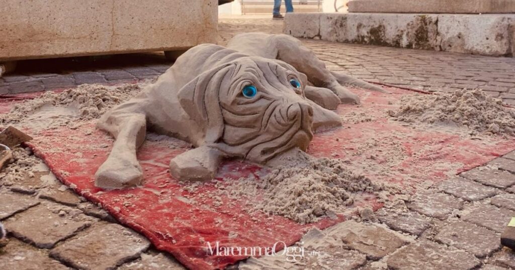 Il cane di sabbia davanti al monumento di Ettore Socci