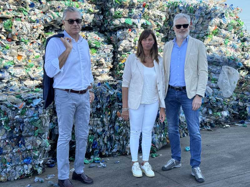 Erika Vanelli, Guido Rustichini e Gianluca Paglia davanti a "balle" di bottiglie di plastica, alla Ecolat