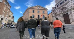 Due coppie di persone affette da obesità camminano mano nella mano (foto simbolica, generata con AI)