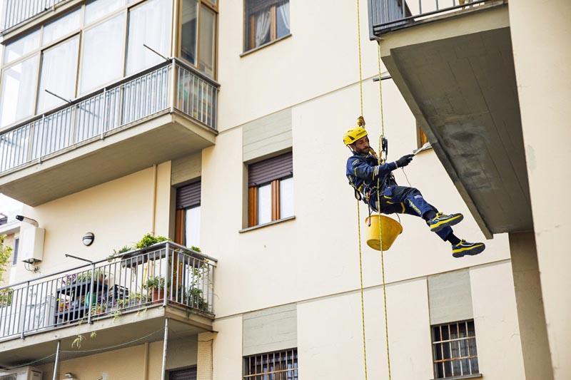 Un operaio di EdiliziAcrobatica al lavoro in città