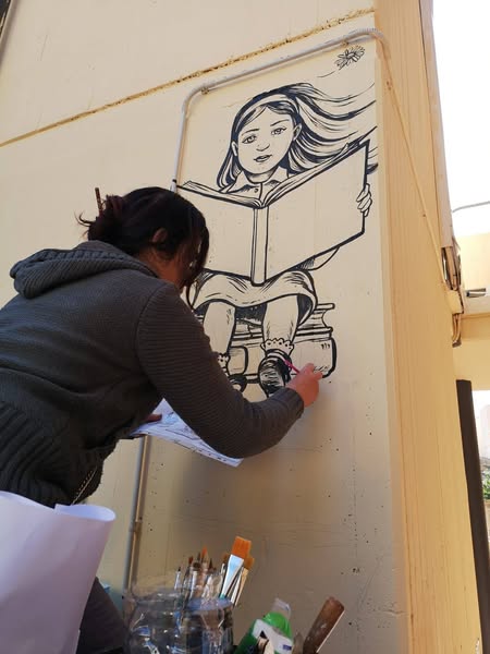 Elena Cannella nella realizzazione del murale per la biblioteca G. Calandra